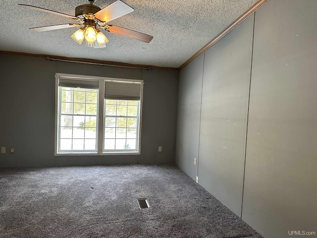 empty room with visible vents, a ceiling fan, a textured ceiling, carpet, and crown molding