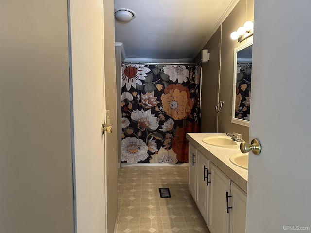 bathroom with a sink, ornamental molding, double vanity, and tile patterned floors