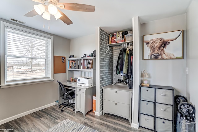 office space featuring visible vents, baseboards, ceiling fan, and light wood finished floors