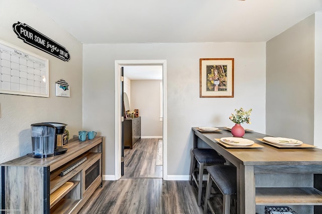 dining space with dark wood-style floors and baseboards