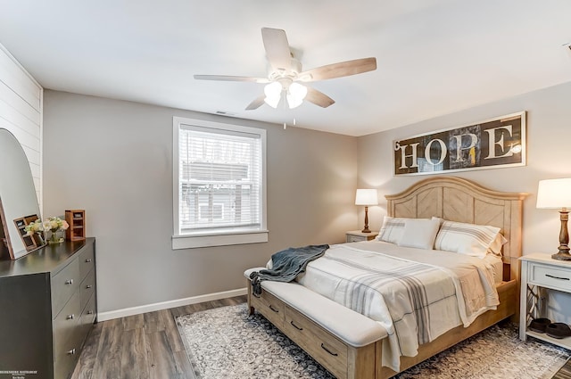 bedroom featuring a ceiling fan, baseboards, and wood finished floors