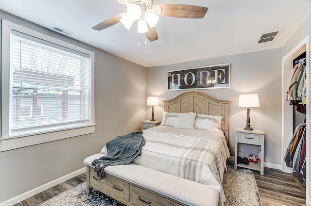 bedroom with visible vents, baseboards, and wood finished floors