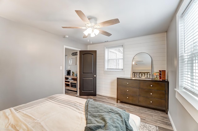 bedroom featuring multiple windows, wood finished floors, and a ceiling fan