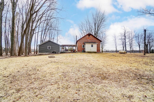 view of yard featuring a detached garage and an outdoor fire pit