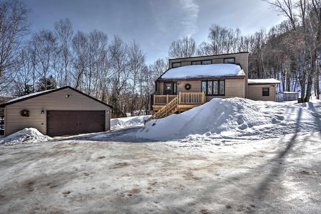 view of front of property featuring a deck, a detached garage, and an outdoor structure