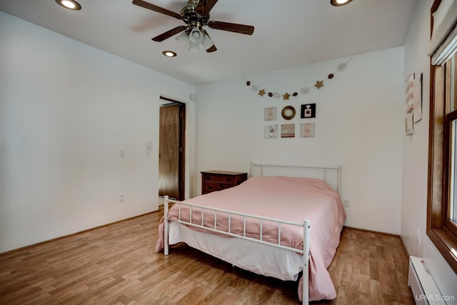 bedroom featuring recessed lighting, a baseboard heating unit, ceiling fan, and wood finished floors