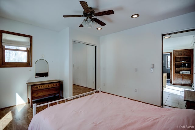 unfurnished bedroom with recessed lighting, a closet, wood finished floors, and a ceiling fan