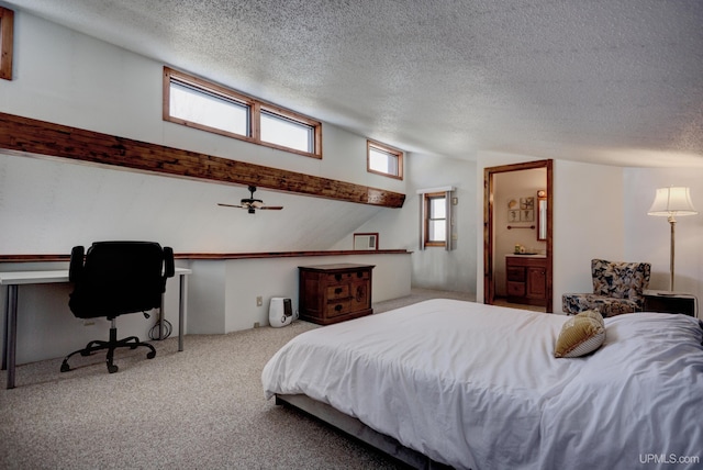 bedroom with lofted ceiling, a textured ceiling, ensuite bathroom, and carpet flooring