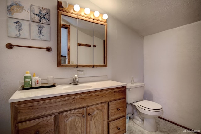 bathroom featuring vanity, vaulted ceiling, and toilet