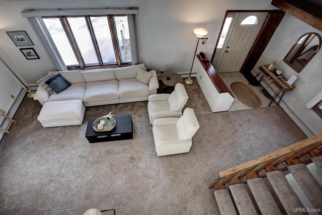 unfurnished living room with stairs, carpet flooring, and a baseboard heating unit