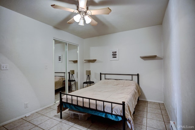 bedroom with tile patterned floors, baseboards, a closet, and ceiling fan