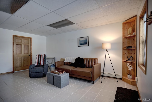 living room featuring light tile patterned floors, a paneled ceiling, baseboards, and a baseboard radiator