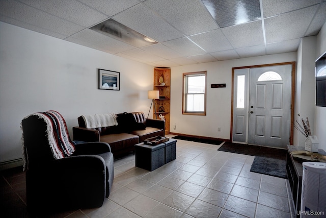 tiled living room with baseboards and a paneled ceiling