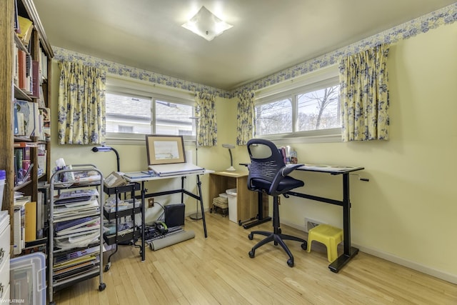 office space with baseboards, wood-type flooring, and a healthy amount of sunlight