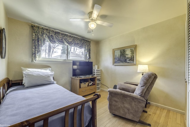 bedroom with light wood-type flooring, baseboards, and a ceiling fan