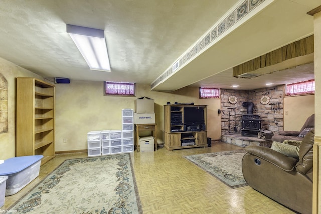 living area with a wood stove, parquet floors, and baseboards