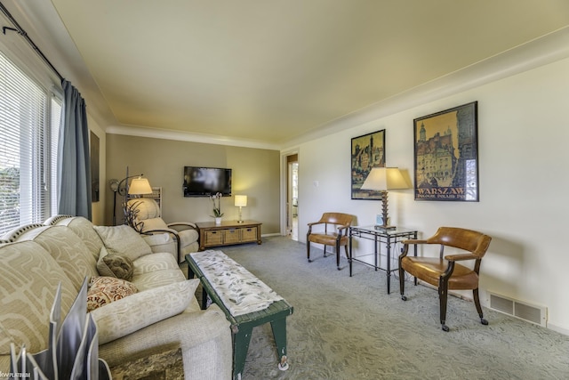 carpeted living area with visible vents, baseboards, and crown molding