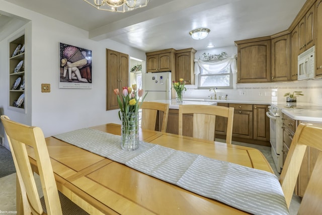 dining area with built in shelves and an inviting chandelier