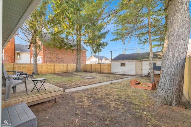 view of yard featuring an outbuilding, a fenced backyard, and a wooden deck