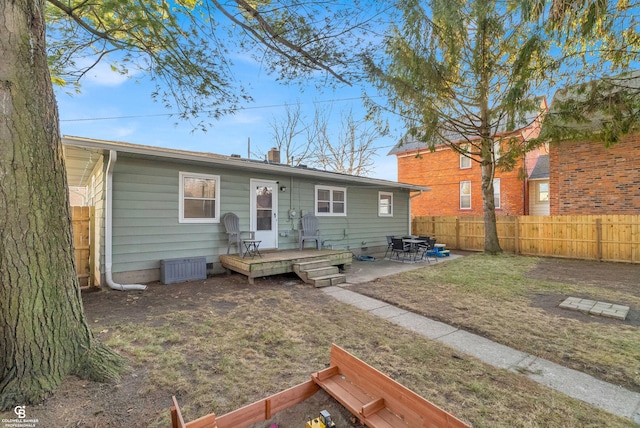 rear view of property with a patio area, a wooden deck, and fence