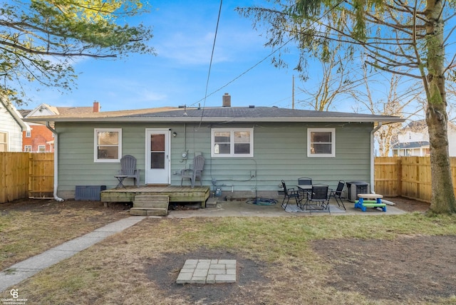 back of property with a patio area, a deck, a lawn, and a fenced backyard