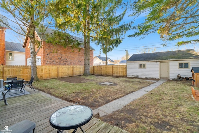 view of yard featuring an outbuilding, a fenced backyard, and a wooden deck