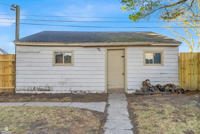 view of outbuilding featuring fence