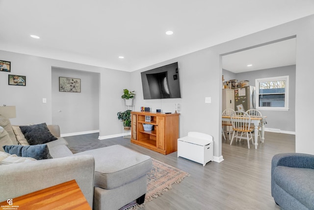 living area with recessed lighting, baseboards, and wood finished floors