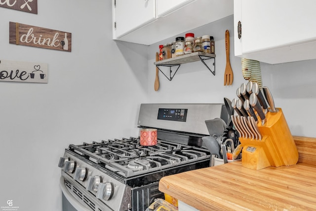 kitchen featuring stainless steel range with gas stovetop and white cabinets