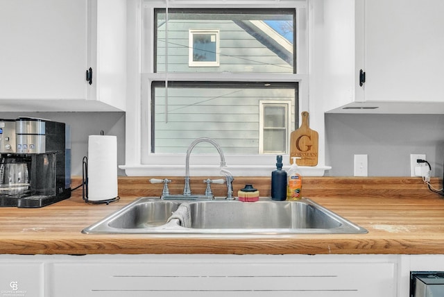 kitchen featuring white cabinetry, light countertops, and a sink