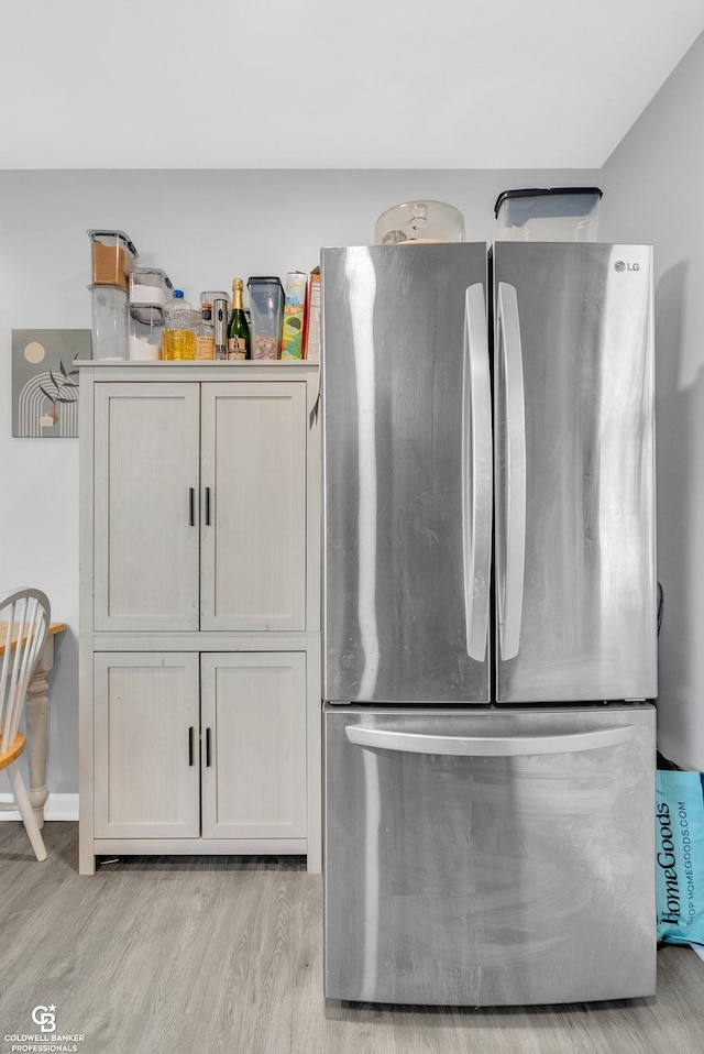 room details featuring light wood-type flooring and freestanding refrigerator