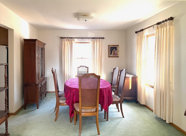 dining space with baseboards, light carpet, and a healthy amount of sunlight