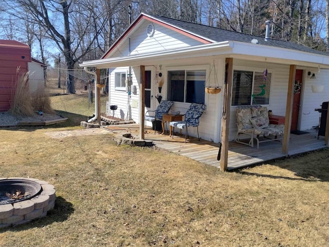 view of front of property featuring a front yard, a fire pit, and covered porch