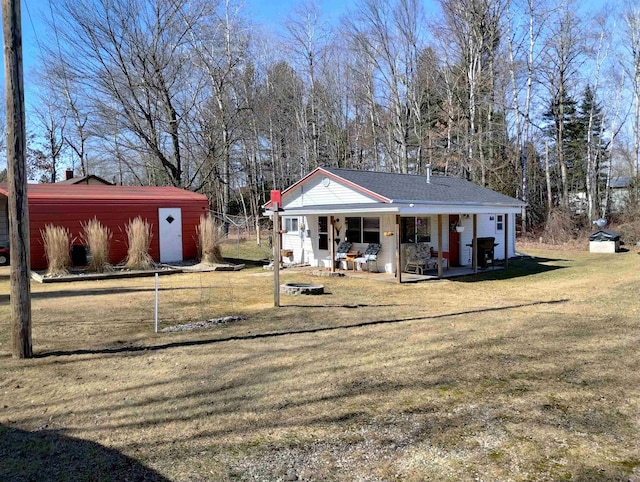 back of house featuring an outdoor structure and a yard