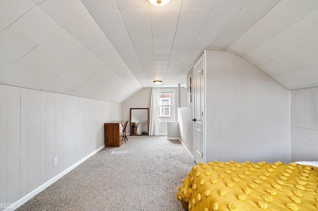 unfurnished bedroom featuring baseboards, carpet floors, and lofted ceiling