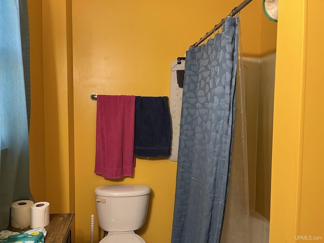 full bath featuring a shower with shower curtain and toilet