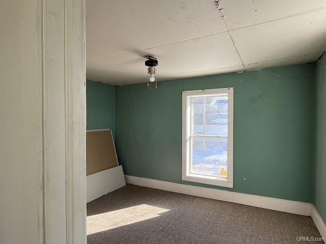 empty room featuring baseboards and carpet