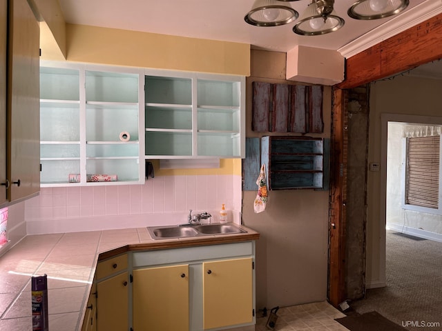 kitchen featuring a sink, open shelves, tasteful backsplash, tile countertops, and light colored carpet