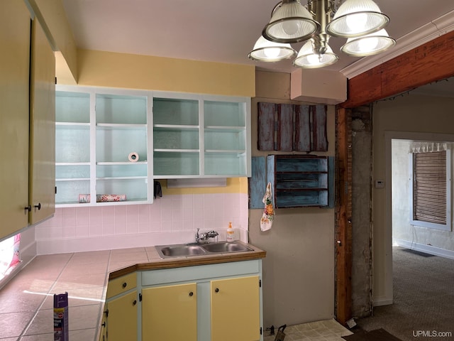 kitchen featuring a sink, open shelves, backsplash, tile countertops, and a chandelier