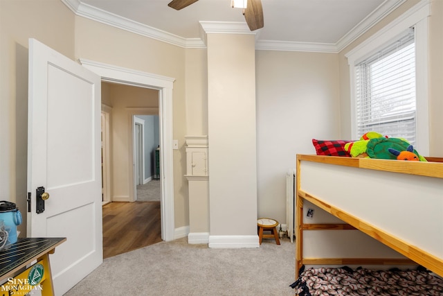 carpeted bedroom with ceiling fan, radiator heating unit, baseboards, and ornamental molding