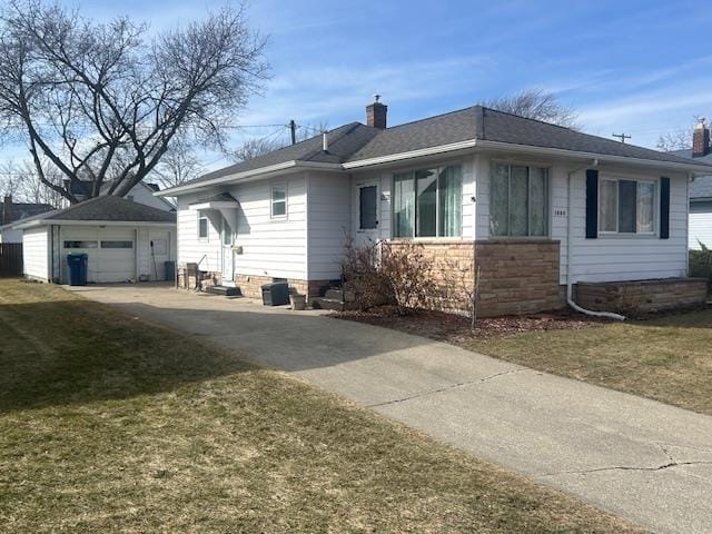 view of front of property with an outbuilding, concrete driveway, a garage, and a chimney