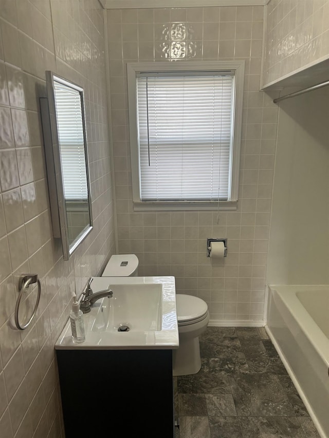 bathroom featuring vanity, tile walls, and toilet