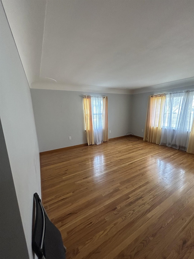 unfurnished room featuring baseboards and wood finished floors