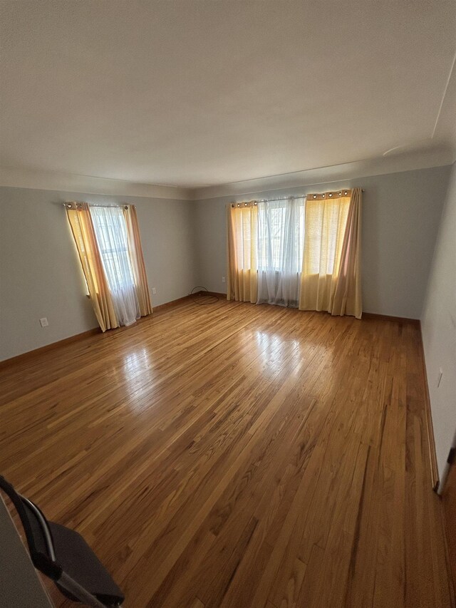 unfurnished room featuring wood finished floors and baseboards