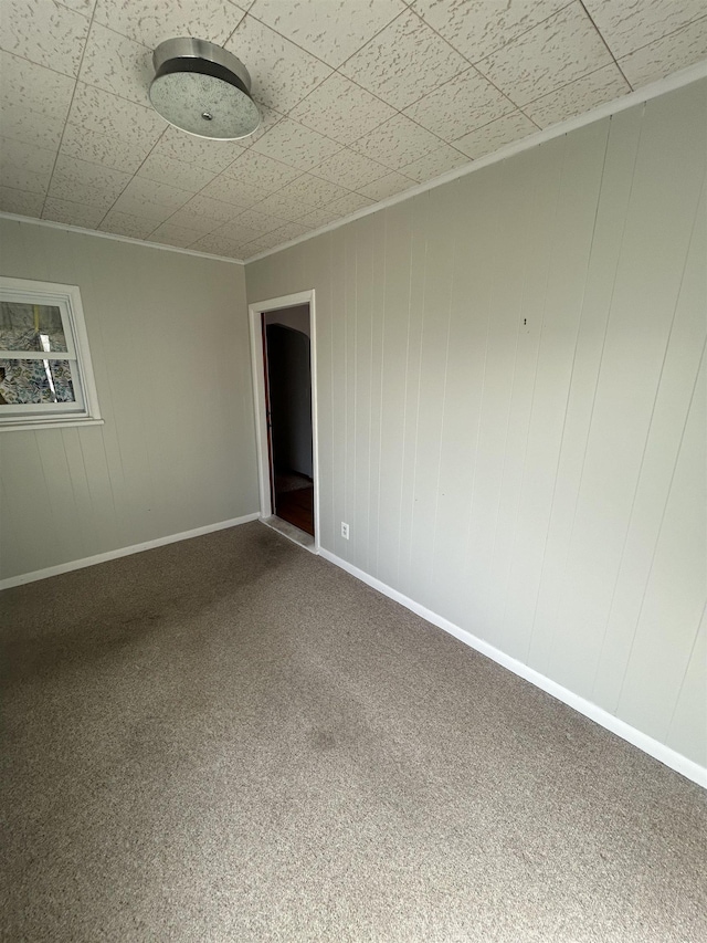 empty room with baseboards and carpet