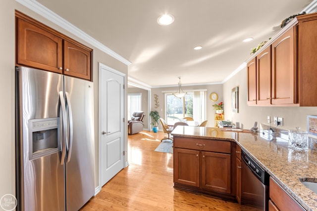 kitchen with appliances with stainless steel finishes, light wood-style floors, a peninsula, and ornamental molding