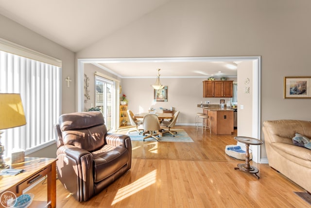 living room with vaulted ceiling, crown molding, light wood-type flooring, and baseboards