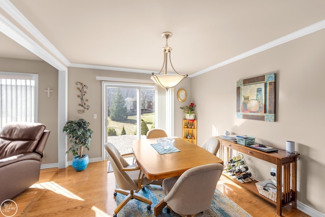 dining room with light wood-style flooring, baseboards, and ornamental molding