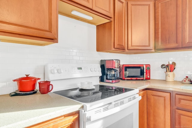 kitchen featuring tasteful backsplash, white electric range oven, and light countertops