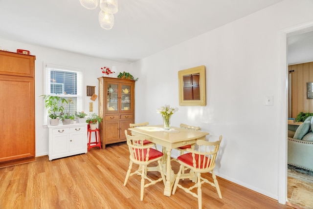 dining space with baseboards and light wood finished floors